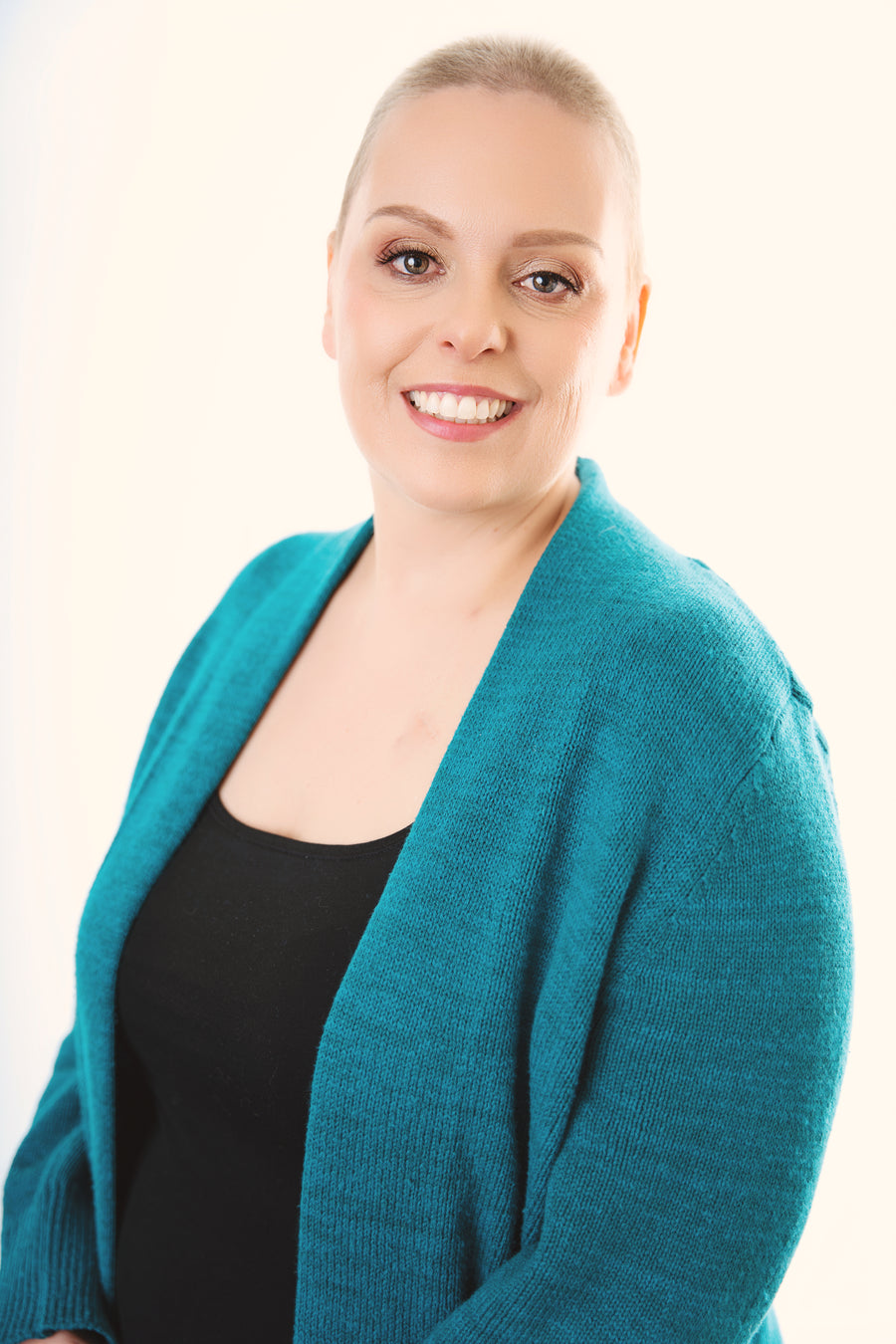 Nicole Martin, Belle Mode co-owner and breast cancer survivor, wearing her teal sweater